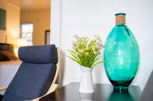 a blue vase and a vase with flowers on a table at Stylish Apt - 2 Queen Bed - Easy Hospital Access in Pittsburgh
