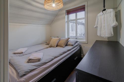 ein großes Bett in einem Zimmer mit Fenster in der Unterkunft Charming and bright apartment in Ålesund city in Ålesund