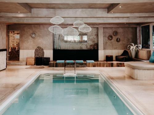 a swimming pool in a room with a living room at Boutique Hotel Haidachhof superior in Fügen