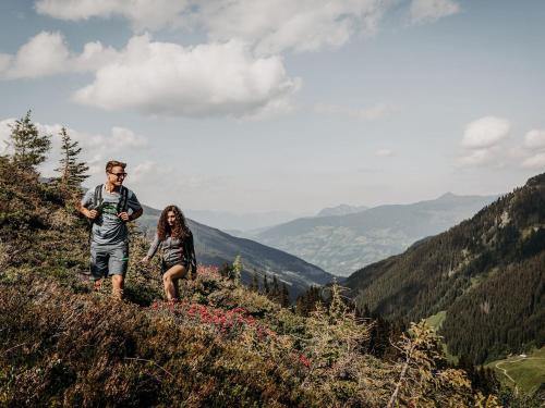 a man and a woman walking on a mountain at Boutique Hotel Haidachhof superior in Fügen