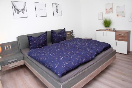 a bed with a blue comforter in a bedroom at FeWo Varis in Röbel