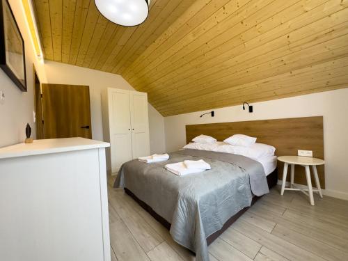 a bedroom with two beds and a wooden ceiling at Na Skraju Puszczy - nowo otwarty in Białowieża