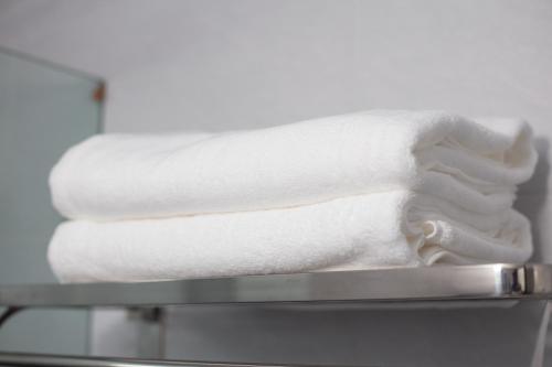 a stack of white towels sitting on a shelf at Central Sapa Charm Hotel in Sa Pa