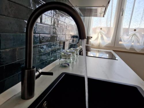 維洛納的住宿－MARCO POLO APARTMENT，厨房水槽配有水龙头,水从外面流出来