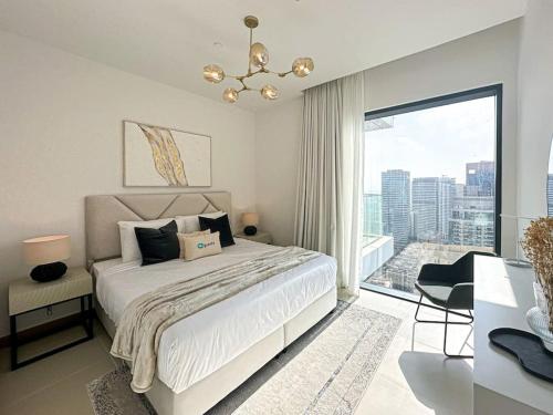 a white bedroom with a bed and a large window at HiGuests - High Level Luxury Apartment With Marina Views in Dubai