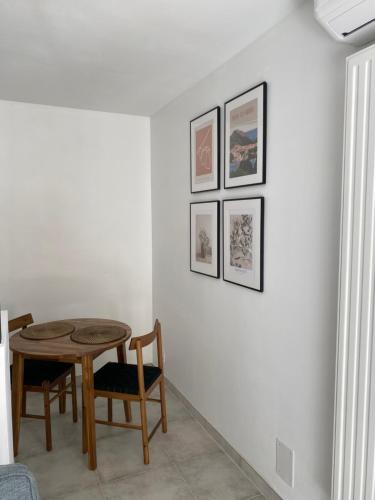 une salle à manger avec une table et trois photos sur le mur dans l'établissement Superbe Studio Centre Digne les bains, à Digne-Les-Bains