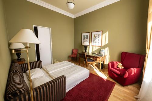 a bedroom with a bed and a red chair at Louisa's Place in Berlin