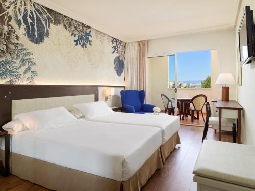 Cette chambre d'hôtel comprend deux lits et une chaise bleue. dans l'établissement H10 Salauris Palace, à Salou