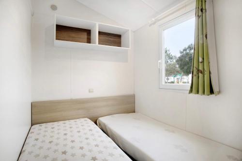 Habitación pequeña con cama y ventana en Bungalow T3 I - 15 Min From Nazaré en Pataias