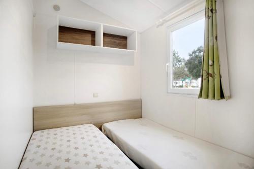 Un dormitorio pequeño con una cama y una ventana. en Bungalow T3 I - 15 Min From Nazaré, en Pataias
