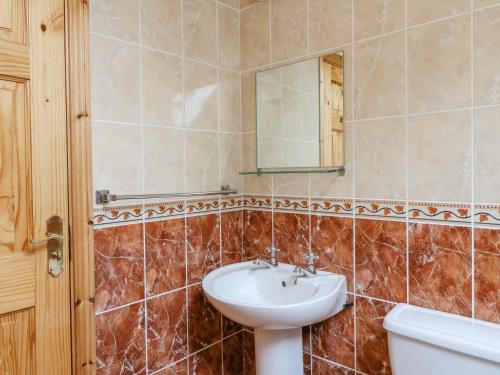 uma casa de banho com um lavatório e um espelho em 14 Sneem Leisure Village em Sneem