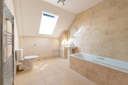 a bathroom with a tub and a toilet and a sink at Duror Cottage at Lower Aylescott in West Down