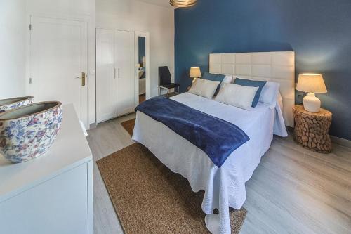 een slaapkamer met een groot bed met blauwe muren bij Luxury Beach Sea Front Guanarame in Playa Honda