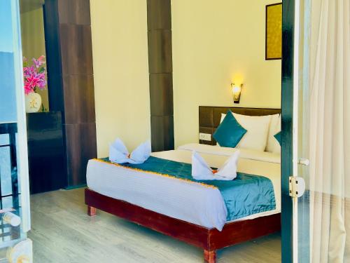 a bedroom with a large bed with blue and white pillows at Tara Palace Resort and SPA in Gangtok