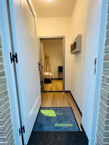 a hallway with a door with a welcome mat on the floor at Parkhotel Gent Centrum in Ghent