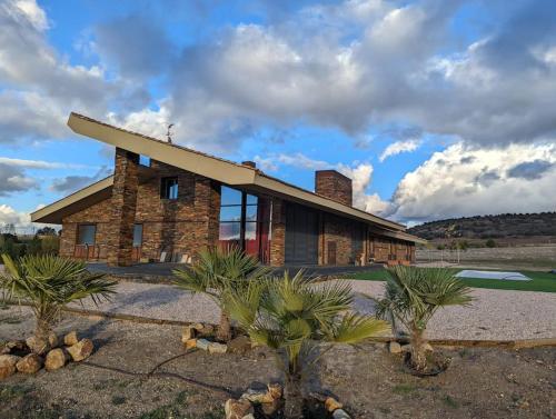 a brick building with palm trees in front of it at Alojamiento rural de lujo en Pedraza-Tejadilla in Valleruela de Pedraza