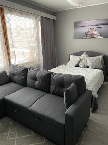 una sala de estar con un sofá y una cama en Polar apartment, en Rovaniemi