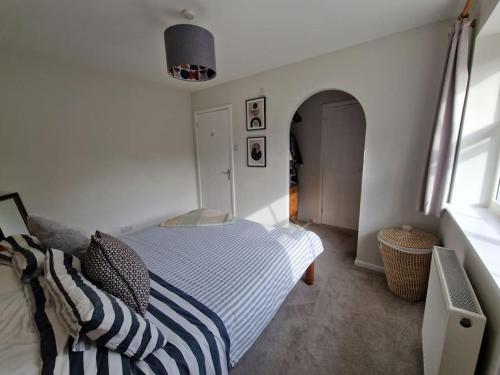 biała sypialnia z łóżkiem i oknem w obiekcie Modern 2 bedroom home with ample parking w mieście Henwick