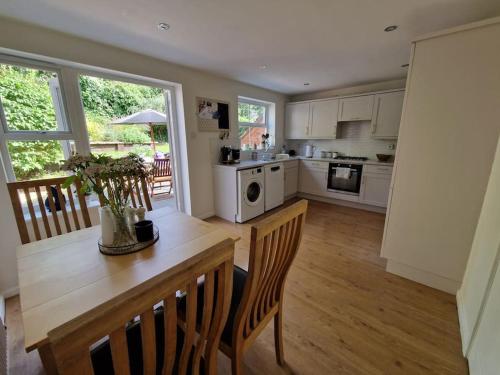 kuchnia z białymi szafkami i drewnianym stołem w obiekcie Modern 2 bedroom home with ample parking w mieście Henwick