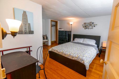 a bedroom with a bed and a table in it at Charming Guest House - Pittsburgh's Little Italy in Pittsburgh