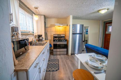 Una cocina con refrigerador de acero inoxidable y una mesa. en Charming Guest House - Pittsburgh's Little Italy, en Pittsburgh