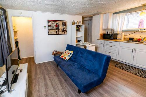a living room with a blue couch and a kitchen at Charming Guest House - Pittsburgh's Little Italy in Pittsburgh