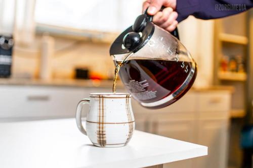a tea kettle being poured into a coffee cup at Charming Guest House - Pittsburgh's Little Italy in Pittsburgh