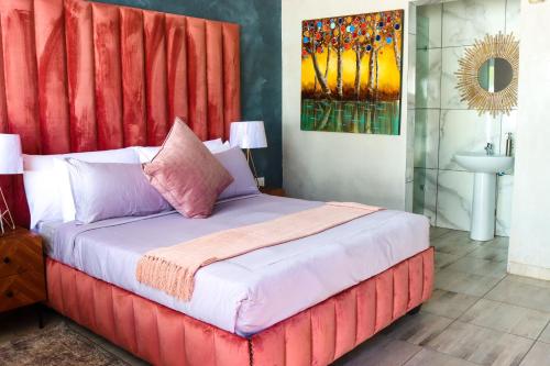 a bed with a red headboard in a room at Suite Boutique Lodge in Pretoria