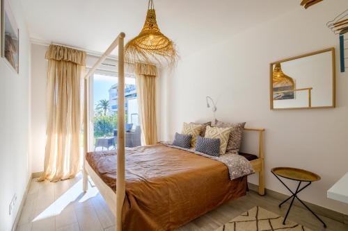 une chambre avec un lit et une grande fenêtre dans l'établissement Le Jasmin, à Nice