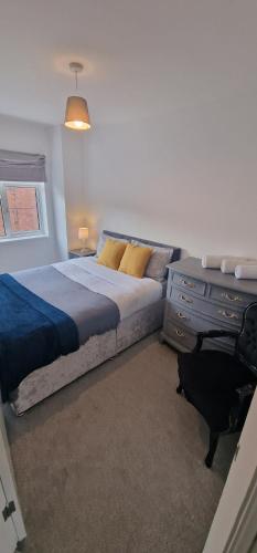 a bedroom with a bed and a dresser in it at Cosy Fresh New Refurbished House in Doncaster