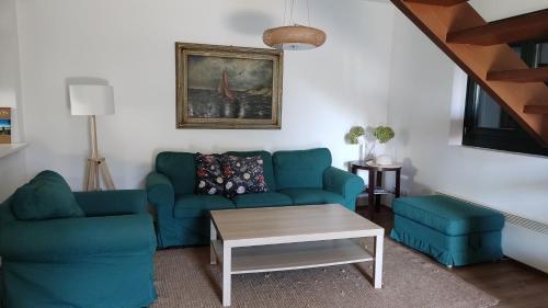 a living room with a blue couch and a table at Peace & Beach House in Tihany, Sajkod in Tihany