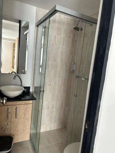 uma casa de banho com uma cabina de duche em vidro e um lavatório. em Hermoso loft en medellin em Medellín