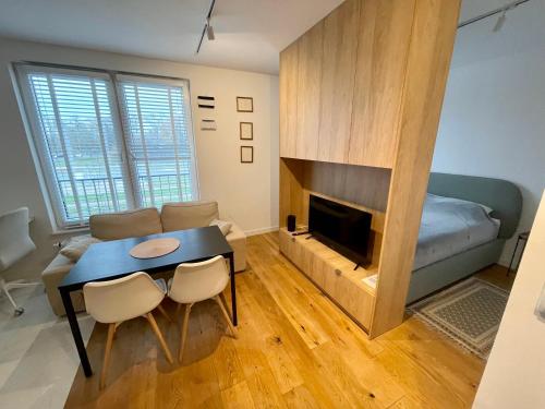 a living room with a table and a fireplace at Time&House Pileckiego przy centrum Onkologi i klinice Novum Apartament na wyłączność pokój,sypialnia,łóżko, łazienka,kuchnia in Warsaw