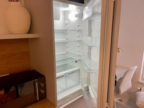 an empty refrigerator with its door open in a room at Time&House Pileckiego przy centrum Onkologi i klinice Novum Apartament na wyłączność pokój,sypialnia,łóżko, łazienka,kuchnia in Warsaw