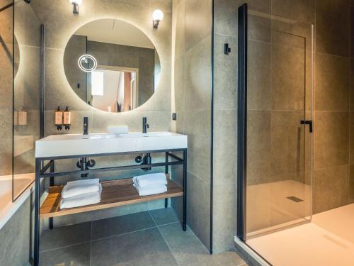 La salle de bains est pourvue d'un lavabo et d'une douche. dans l'établissement Mercure Troyes Centre, à Troyes