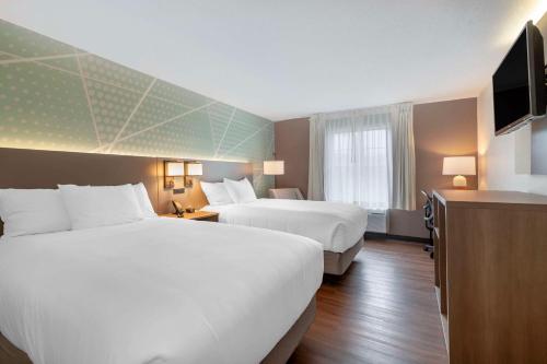 a hotel room with two beds and a television at Comfort Inn Airport in South Portland