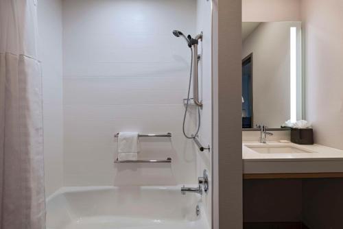 a bathroom with a bath tub and a sink at Hyatt Place Tulsa/Downtown in Tulsa