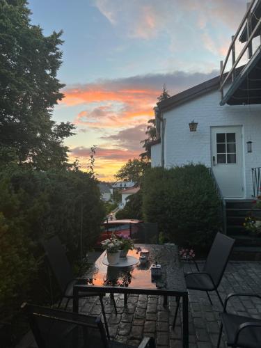 eine Terrasse mit einem Tisch und Stühlen bei Sonnenuntergang in der Unterkunft Lugnt och centralt läge in Borås