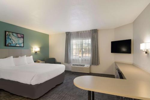 um quarto de hotel com uma cama grande e uma secretária em MainStay Suites Denver Tech Center em Centennial