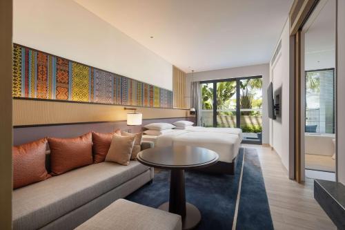 a hotel room with two beds and a couch and a table at Hyatt Regency Sanya Tianli Bay in Sanya