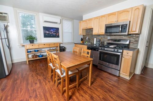 a kitchen with a wooden table and a stove top oven at 1 BR - Parking - Amazing View Nearby! in Pittsburgh