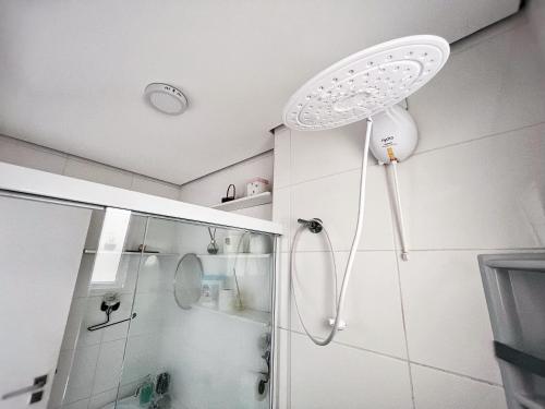eine Dusche mit Duschkopf im Bad in der Unterkunft Confortável apartamento perto de praias - Bertioga in Bertioga