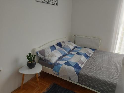 una camera con letto e tavolo con una pianta in vaso di Nikola NS a Novi Sad