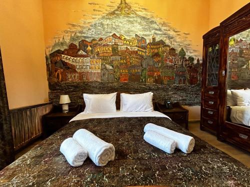 a bedroom with a large bed with towels on it at Hotel Zerta Old Tbilisi in Tbilisi City