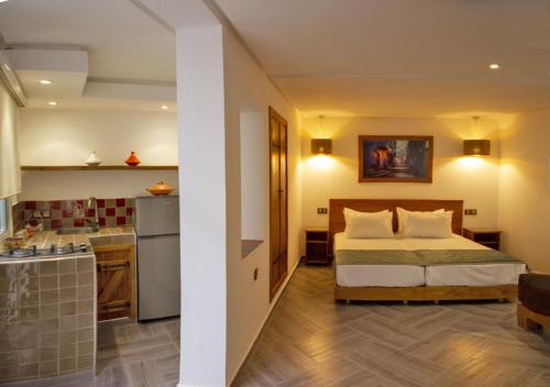 pokój hotelowy z łóżkiem i kuchnią w obiekcie Aparthotel Dar Nowara Chaouen w mieście Szafszawan