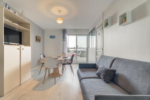 una sala de estar con un sofá y una mesa en Appartement vue Mer, en Saint-Cast-le-Guildo