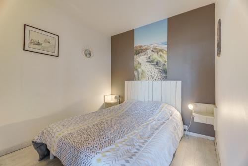 a bedroom with a bed with a painting on the wall at Appartement vue Mer in Saint-Cast-le-Guildo