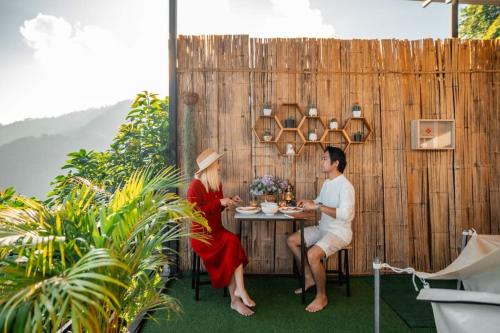 a man and a woman sitting at a table at ฮิมสวน โฮมสเตย์ Him suan homestey in Ban Thung Phan Ha