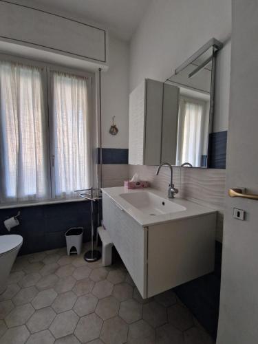 a bathroom with a sink and a toilet and a mirror at La Casa di Emy in Bordighera