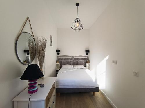 - une chambre avec un lit, un miroir et une lampe dans l'établissement Superbe 2 pièces Carré d’or avec grande Terrasse, à Nice